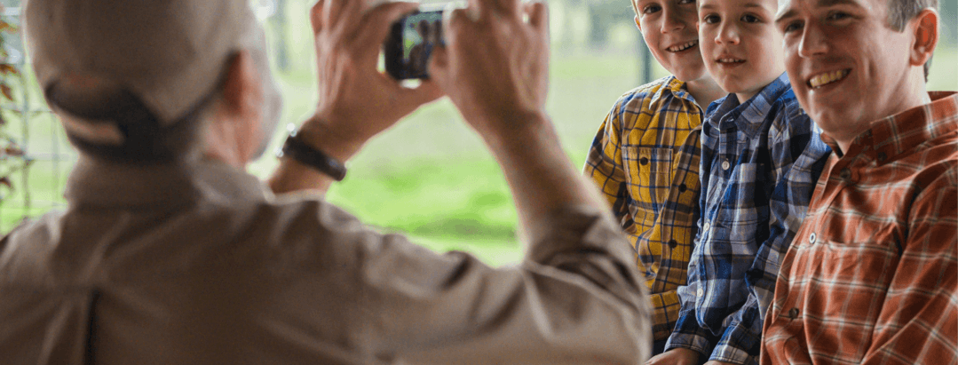 man taking image of different generations of family